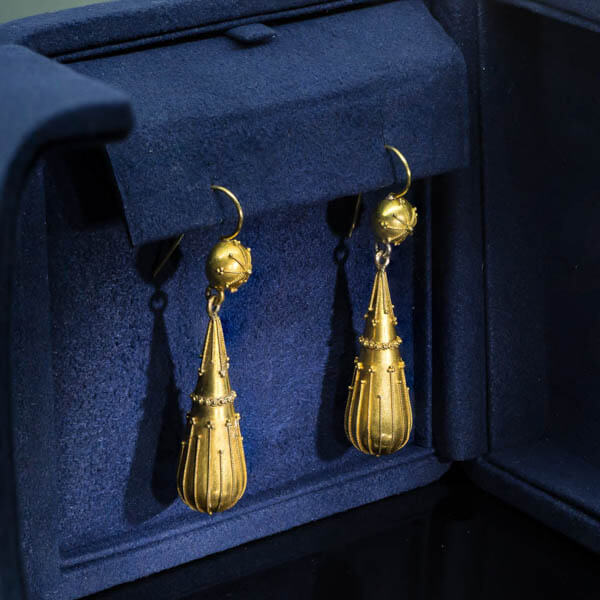 A pair of antique Etruscan Revival yellow-gold drop earrings with a matte finish illustrating bloomed gold. 