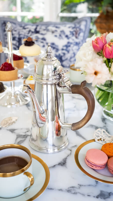 An afternoon tea table set with a silver coffee pot